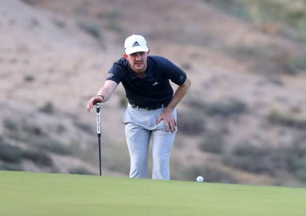 Connor Syme lines up a putt before play was suspended due to high winds in the second round of the Oman Open. Picture: Getty Images