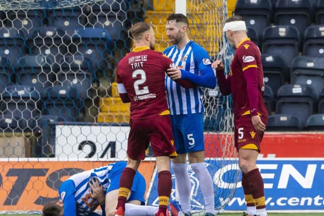 Kilmarnock's Stephen O'Donnell collapses to the ground as Richard Tait and Kirk Broadfoot exchange words. Pic: SNS/Alan Harvey