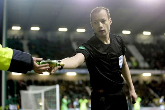 Referee Willie Collum removes a bottle from the pitch during the Hibs v Celtic Scottish Cup clash at Easter Road. Picture: PA