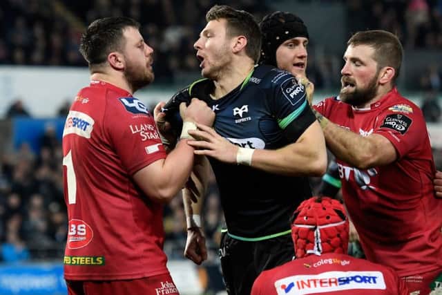 Scarlets prop Rob Evans (left) gets to grips with international team-mate and Ospreys fly-half Dan Biggar during a feisty PRO12 clash. The teams could merge in time for the 2019/20 season. Picture: Getty Images