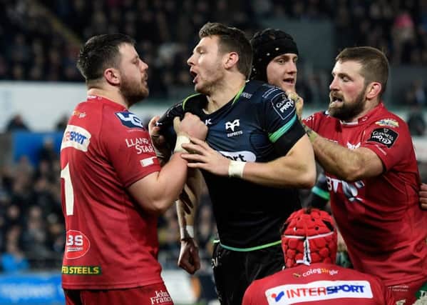 Scarlets prop Rob Evans (left) gets to grips with international team-mate and Ospreys fly-half Dan Biggar during a feisty PRO12 clash. The teams could merge in time for the 2019/20 season. Picture: Getty Images