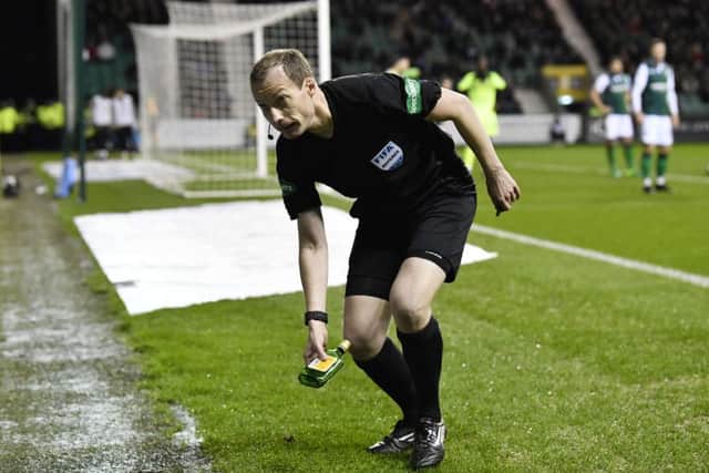 Referee Willie Collum removes the bottle from the pitch. Picture: SNS Group