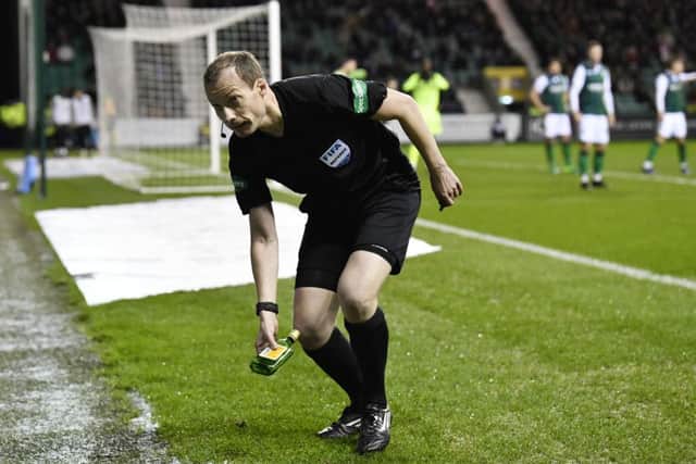 Referee Wiillie Collum removes the bottle thrown towards Scott Sinclair at Easter Road. Picture: Rob Casey/SNS