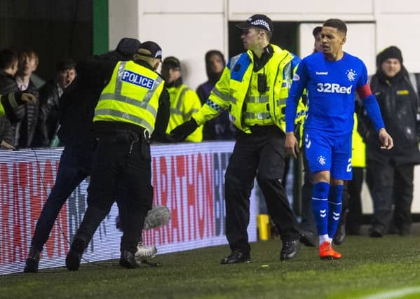 The fan is led away by police after confronting James Tavernier. Picture: SNS