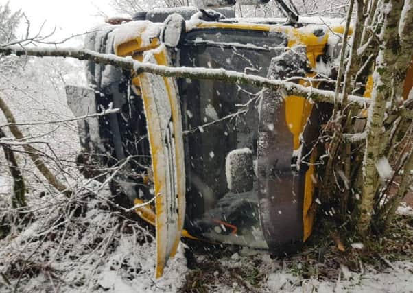 A gritter has crashed off road and overturned as Scotland was hit with snow and icy winds.