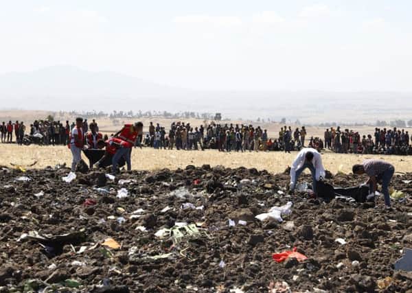 Rescue team collect remains of bodies amid debris at the crash site of Ethiopia Airlines near Bishoftu, a town some 60 kilometres southeast of Addis Ababa, Ethiopia. Picture: MICHAEL TEWELDE/AFP/Getty Images