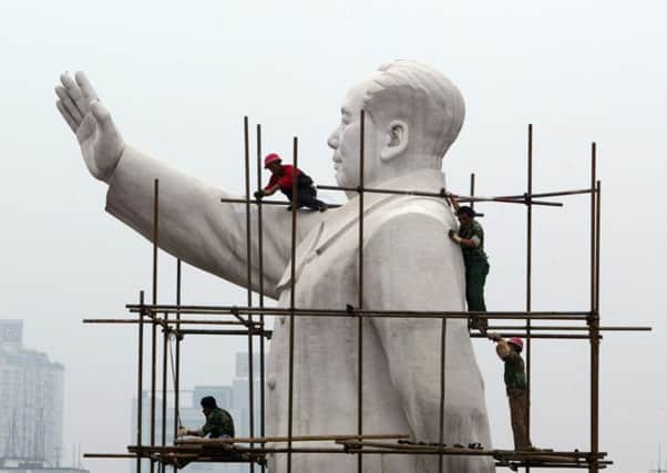 Workers build a scaffold to clean the statue of former Chinese leader Mao Zedong in Chengdu, Sichuan Province. PIC: China Photos/Getty Images