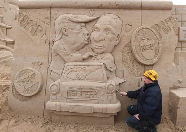 Wodek Bludik works on his sculpture Berlin Wall featuring Donald Trump and Vladimir Putin at the sand-sculpting festival in Binz on the Baltic Sea (Picture: Stefan Sauer/AFP/Getty Images)