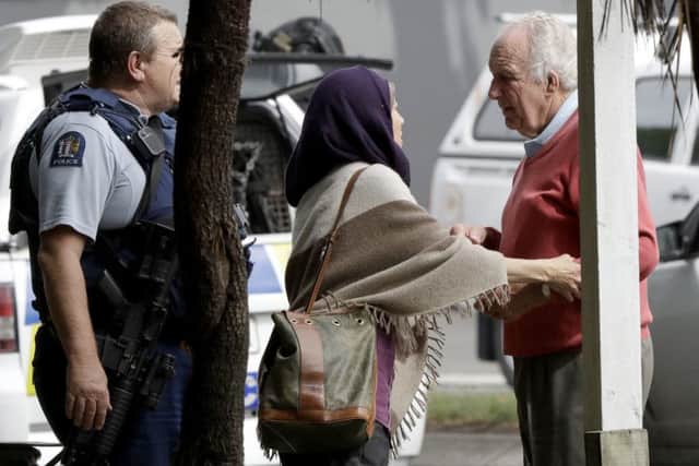 Police escort people away from outside a mosque in central Christchurch. (AP Photo/Mark Baker)