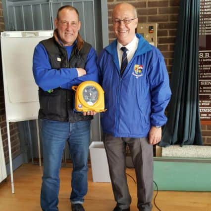 Mr Blair Watson from the Dean Trust along with Newbattle Bowling Club's Vice President Mr Peter Whitecross with the newly acquired defibrillator.