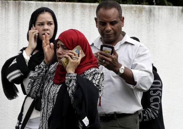 People wait outside a mosque in central Christchurch following the mass shooting (Picture: Mark Baker/AP)