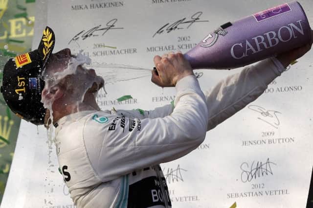 Mercedes driver Valtteri Bottas of Finland sprays himself with champagne after winning the Australian Grand Prix ahead of team-mate Lewis Hamilton. Picture: AP.