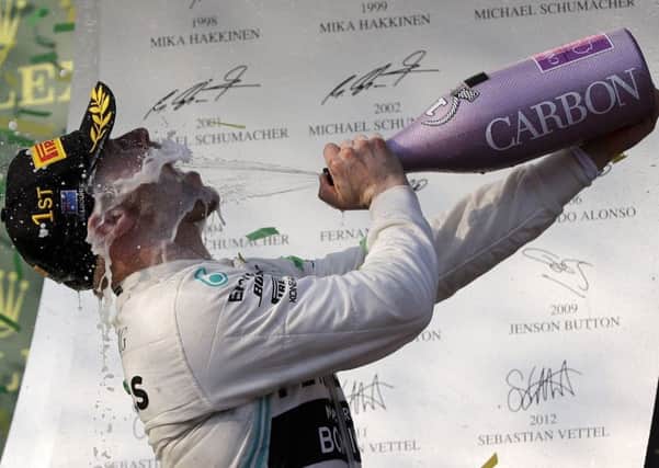 Mercedes driver Valtteri Bottas of Finland sprays himself with champagne after winning the Australian Grand Prix ahead of team-mate Lewis Hamilton. Picture: AP.