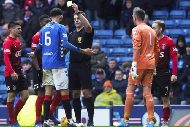 Referee Greg Aitken shows Connor Goldson a yellow card following his foul on Liam Millar. Picture: SNS.