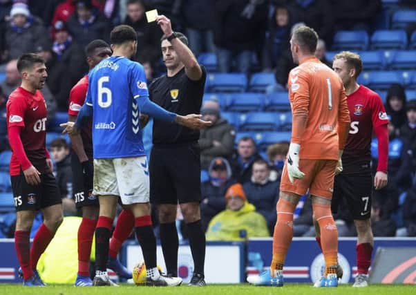 Referee Greg Aitken shows Connor Goldson a yellow card following his foul on Liam Millar. Picture: SNS.