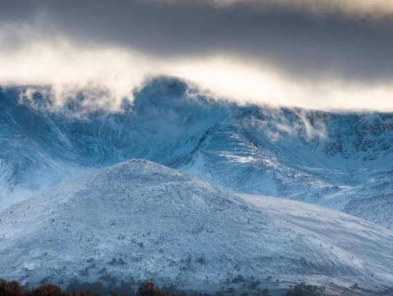 A snow boarder survived being stranded on top of a mountain in the Highlands by hugging his dog for warmth.