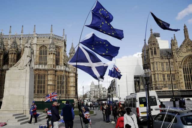 Pro-EU campaigners outside Westminster fly EU and Scottish flags. Picture: AP/Matt Dunham