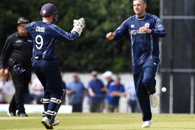 Mark Watt, right, celebrates a wicket against England with Matthew Cross. Picture: SNS Group