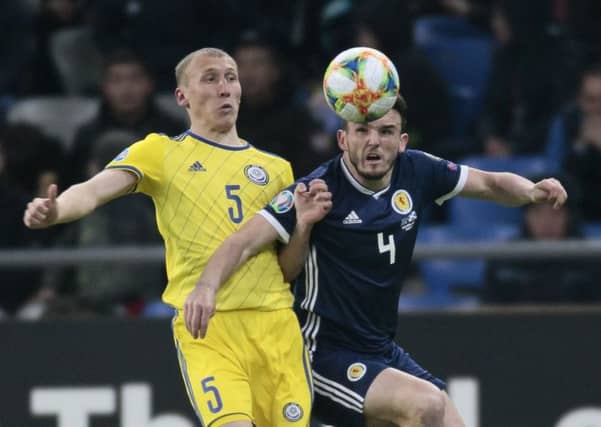 Scotland midfielder John McGinn challenges for the ball with Islambek Kuat of Kazakhstan. Picture: Alexei Filippov/AP