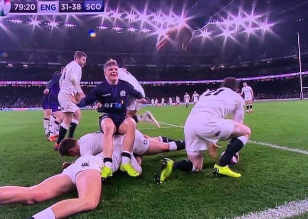 Darcy Graham finds time to take a seat on England players during the extraordinary second half at Twickenham.