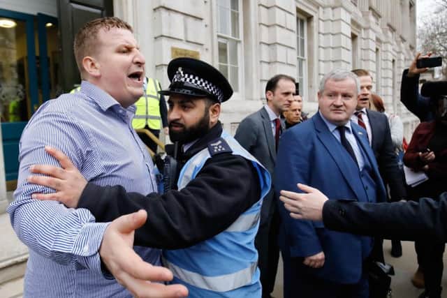 Police restrain a man who was shouting pro-Brexit slogans at Scottish National Party (SNP) MP and Westminster leader Ian Blackford. Picture: Getty Images