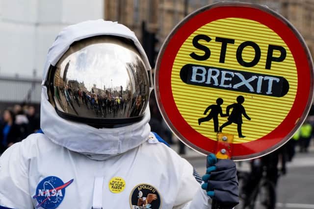 A person dressed as an astronaught holding a school traffic crossing sign reading "Stop Brexit" joins a march and rally organised by the pro-European People's Vote campaign. Pic: Niklas Halle'n/AFP/Getty Images