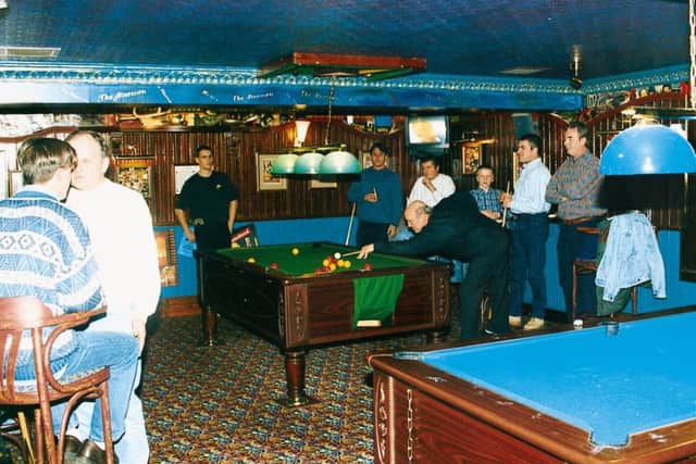 Some pub-goers enjoy a game of pool .