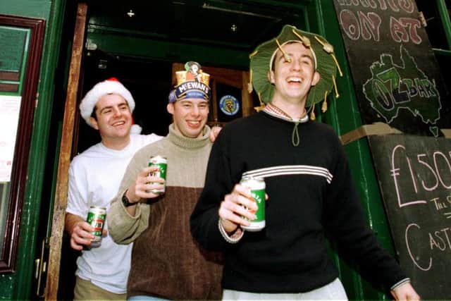 Three revellers see in the New Year in 1999.