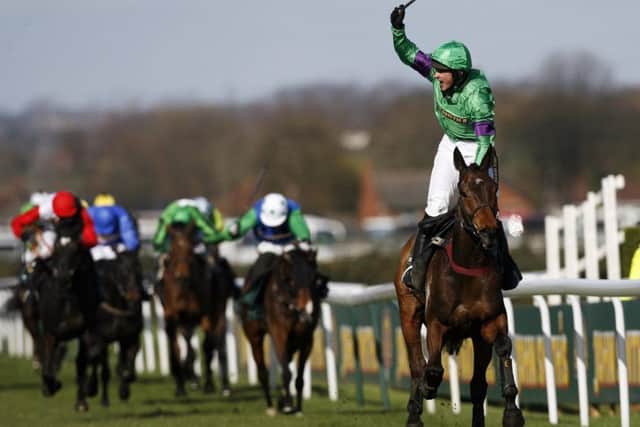 Jockey Liam Treadwell stands up in his irons to celebrate Mon Mome's 2009 Grand National victory. Picture: Paul Ellis/AFP/Getty