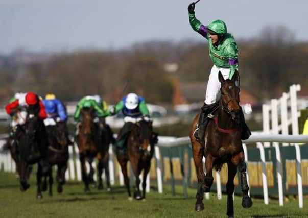 Jockey Liam Treadwell stands up in his irons to celebrate Mon Mome's 2009 Grand National victory. Picture: Paul Ellis/AFP/Getty