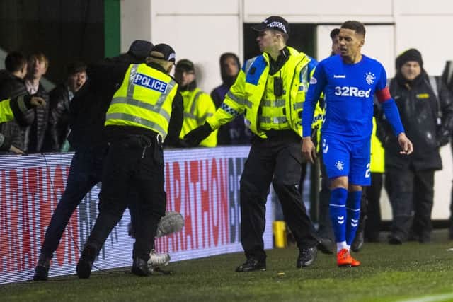 Police detain a Hibs fan who confronted Rangers captain James Tavernier on the pitch. Picture: SNS Group