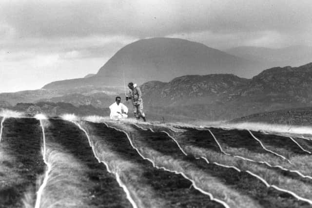 Two scientists decontaminate an area of Gruinard in 1986 using a solution of formaldehyde and sea water. PIC: TSPL.