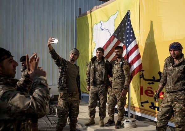 American-backed forces celebrate victory against Isis in Baghouz, Syria, with a selfie. Picture: Chris McGrath/Getty