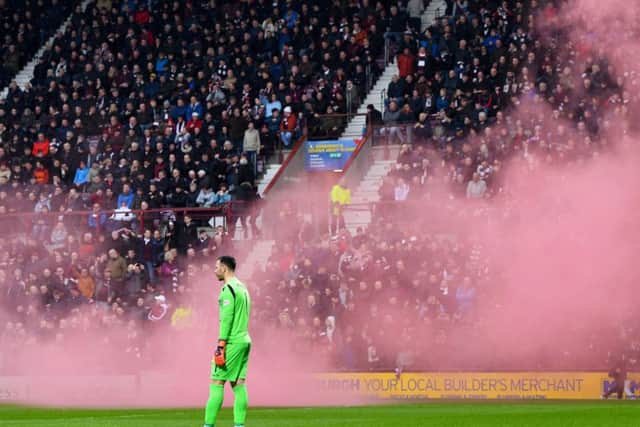 Ofir Marciano watches after a smoke bomb is let off at the side of the pitch. Pic: SNS/Craig Williamson