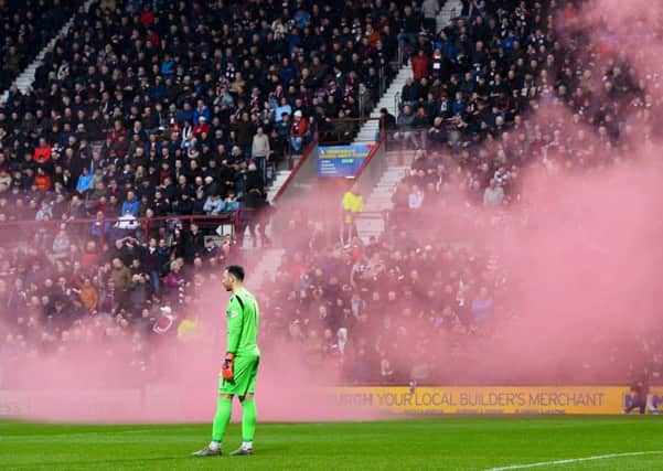 Ofir Marciano watches after a smoke bomb is let off at the side of the pitch. Pic: SNS/Craig Williamson