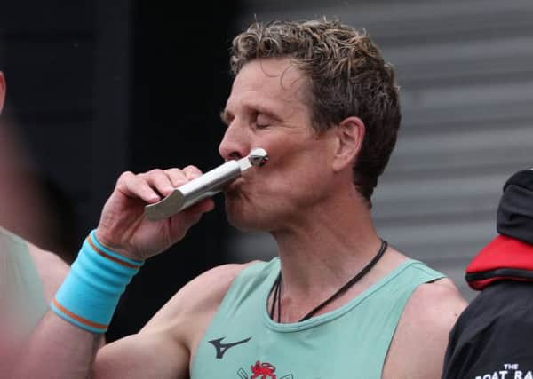 James Cracknell swigs from a hip flask after winning the mens boat race between Cambridge and Oxfrord. Picture: SWNS