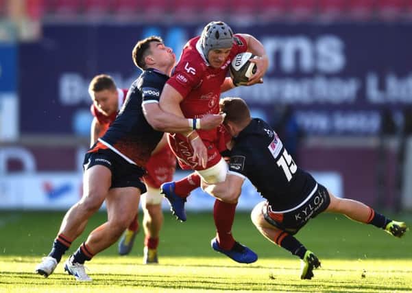 Damien Hoyland, left, and Darcy Graham team-up to bring down Scarlets' centre Jonathan Davies. Picture: Ben Evans/Huw Evans/REX/Shutterstock