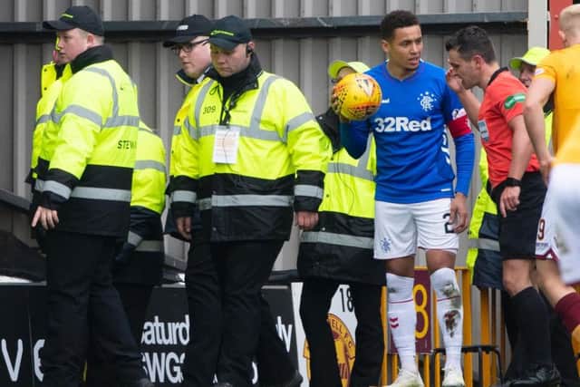 James Tavernier talks to referee Nick Walsh after objects thrown at him. Picture: SNS
