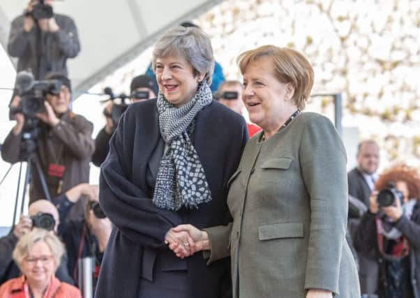 Theresa May and Angela Merkel shake hands for the cameras but the German Chancellor was not there to greet the UK leader when she first arrived (Picture: Omer Messinger/Getty Images)