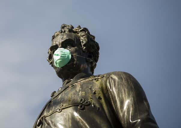 Protesters gave a mask to a statue in Glasgow's George Square to make a point about air pollution (Picture: John Devlin)