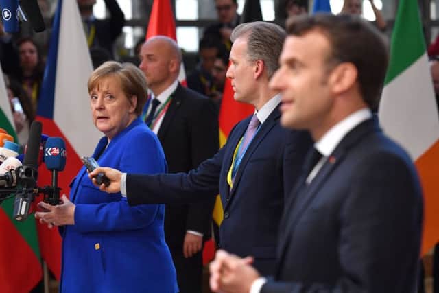 Germany's Chancellor Angela Merkel looks back at French President Emmanuel Macron as they speak to the media ahead of a European Council meeting on Brexit. (Photo by Leon Neal/Getty Images