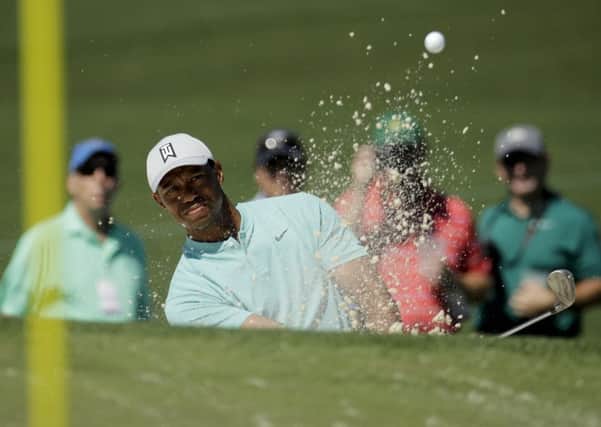 Tiger Woods hits out of the bunker on the second hole during practice. Picture: Charlie Riedel/AP