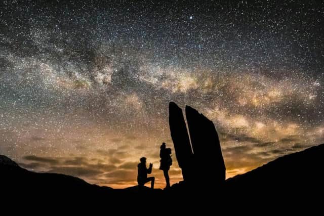 These incredible photos show Connor McLaren, 23, proposing to Jamie McGregor, 29, silhouetted against the Milky Way on top of Glen Lyon, Perth and Kinross. Picture: Conor McLaren /SWNS