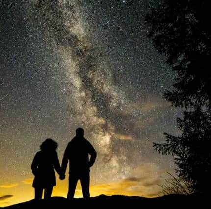 These incredible photos show Connor McLaren, 23, proposing to Jamie McGregor, 29, silhouetted against the Milky Way on top of Glen Lyon, Perth and Kinross. Picture: Conor McLaren /SWNS