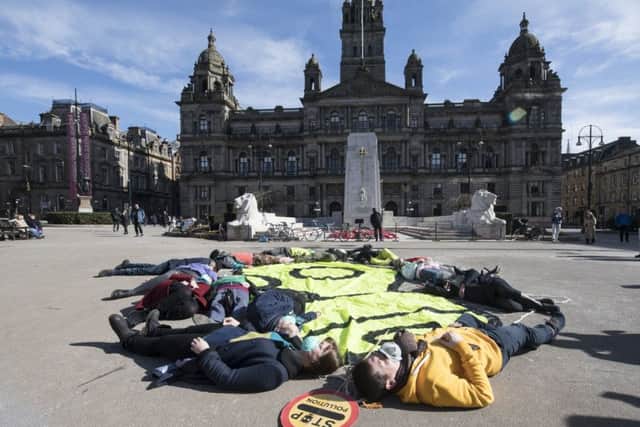 Air pollution protesters wearing gas masks stage a die-in in Glasgows George Square (Picture: John Devlin)