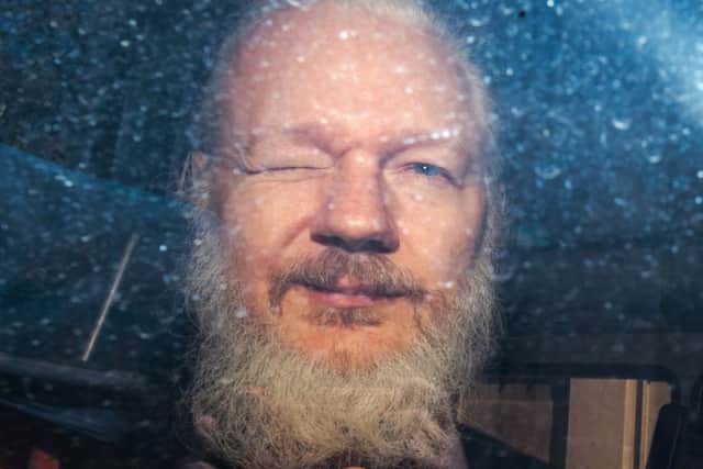 Julian Assange gestures to the media from a police vehicle on his arrival at Westminster Magistrates Court. Picture: Jack Taylor/Getty Images