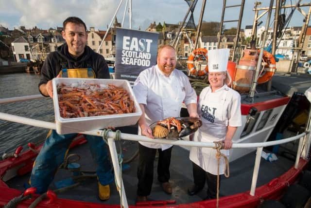 Skipper Michael Bruce with his langoustine catch, with prize winning seafood chefs Craig Millar, and Abbie Clunie.