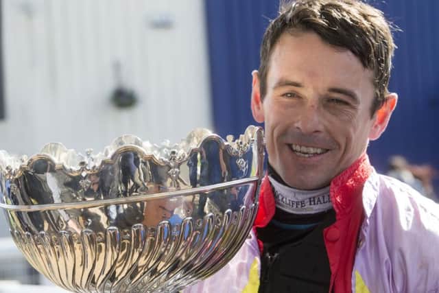Sean Quinlan celebrates with the trophy after winning the Coral Scottish Grand National Handicap Chase onboard Takingrisks. Pic: Jeff Holmes/PA