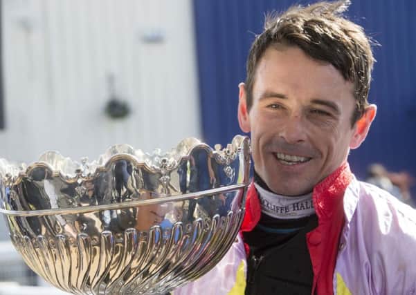 Sean Quinlan celebrates with the trophy after winning the Coral Scottish Grand National Handicap Chase onboard Takingrisks. Pic: Jeff Holmes/PA