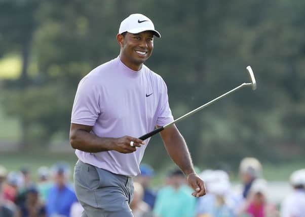 Tiger Woods smiles as he walks on the 18th hole during the third round at Augusta National. Picture: Getty Images